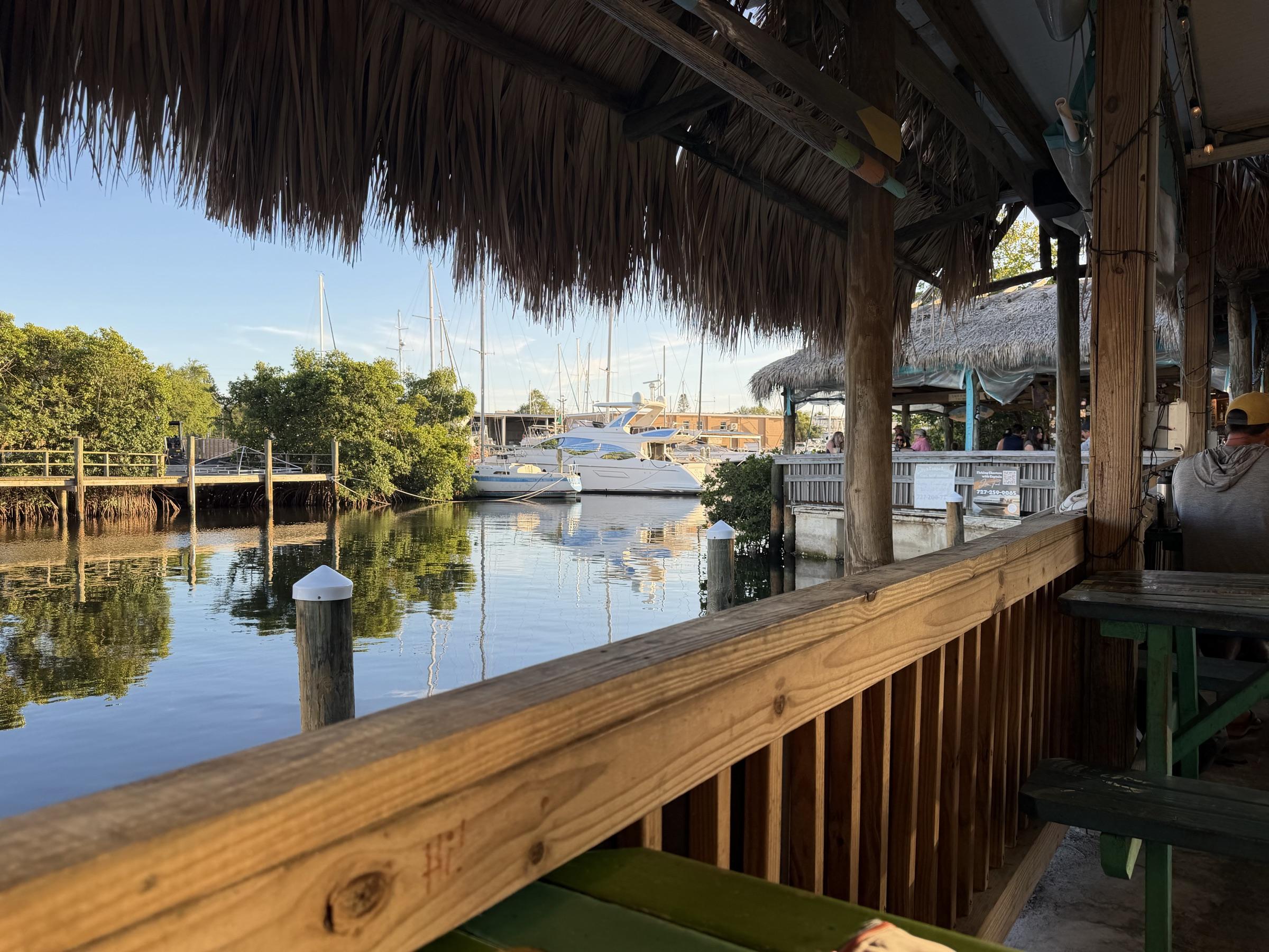 Tiki bar overlooking a marina at golden hour.